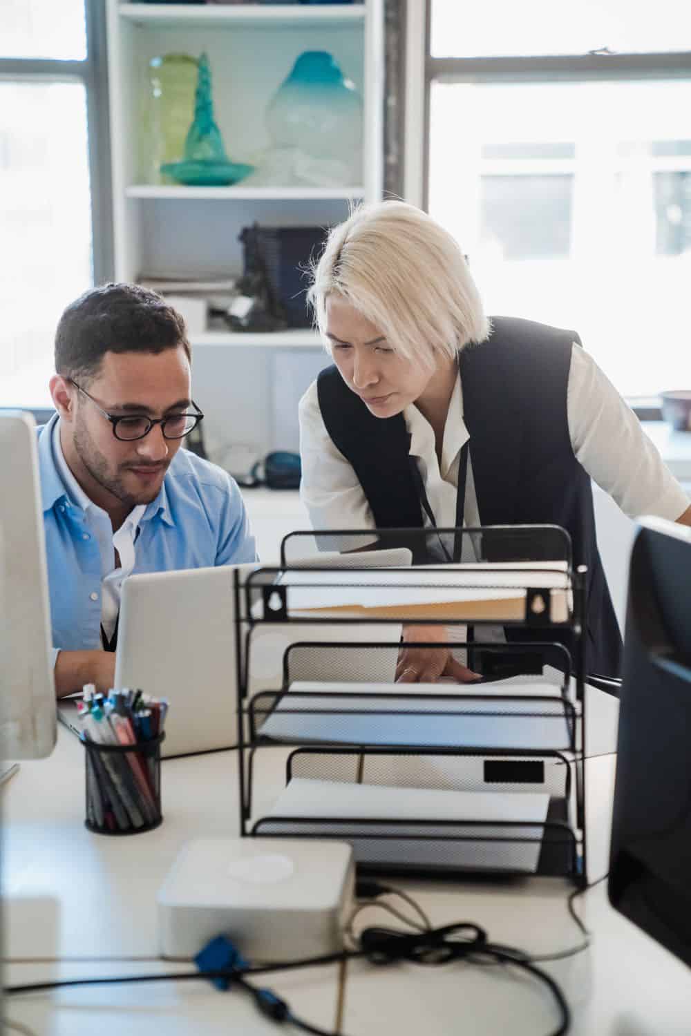 Two professionals reviewing work together at a laptop, illustrating a white-label agency partnership